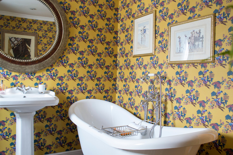 Cette image montre une salle de bain traditionnelle avec une baignoire sur pieds, un mur multicolore et un lavabo de ferme.