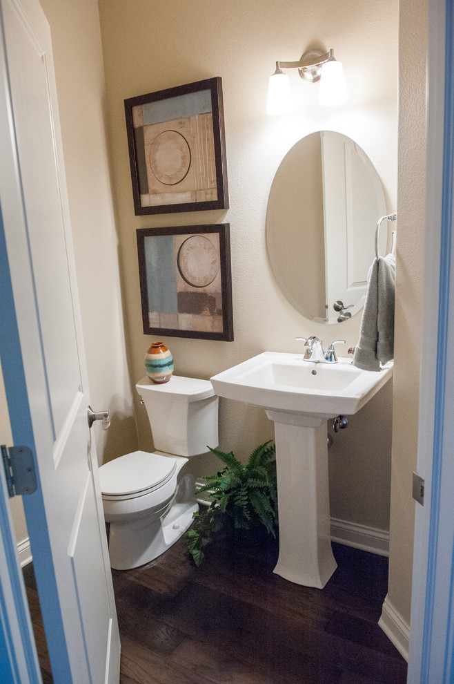 Immagine di una stanza da bagno con doccia minimal di medie dimensioni con lavabo a colonna, WC monopezzo, pareti beige e parquet scuro