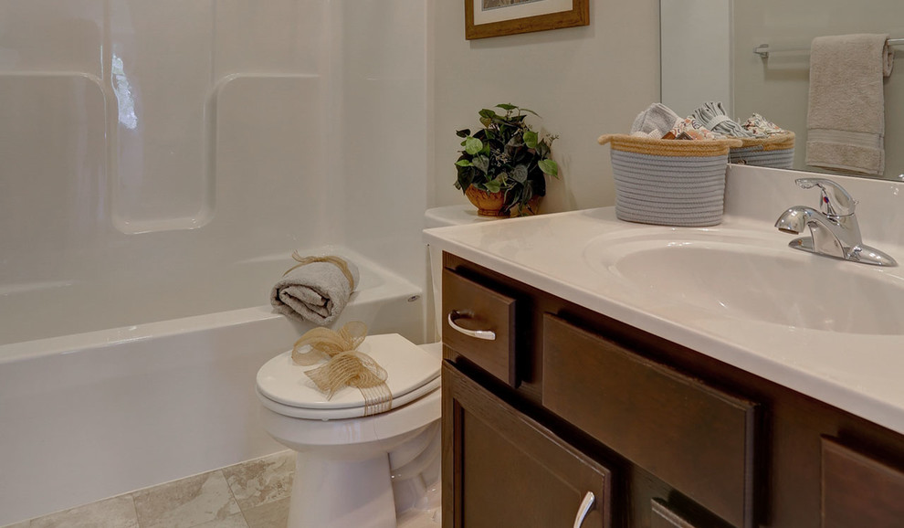 Exemple d'une grande salle de bain chic en bois brun pour enfant avec un combiné douche/baignoire, WC séparés, un mur beige, un sol en carrelage de céramique, un lavabo intégré, un plan de toilette en marbre, un sol beige, une cabine de douche avec un rideau et un plan de toilette blanc.