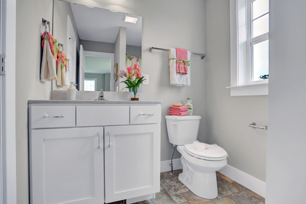 Aménagement d'une salle de bain craftsman de taille moyenne pour enfant avec des portes de placard blanches, un combiné douche/baignoire, WC séparés, un mur beige, un sol en vinyl, un lavabo intégré, un plan de toilette en marbre et une cabine de douche avec un rideau.