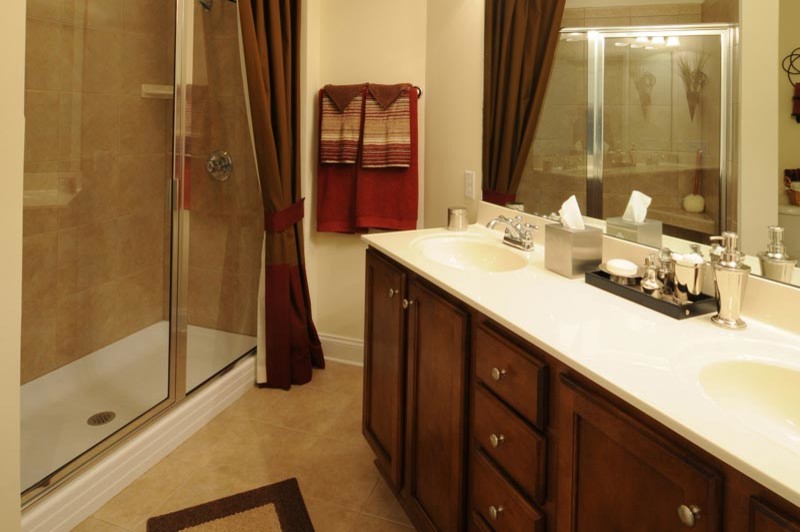 Immagine di una stanza da bagno chic con lavabo integrato, ante in legno bruno, doccia ad angolo e WC a due pezzi