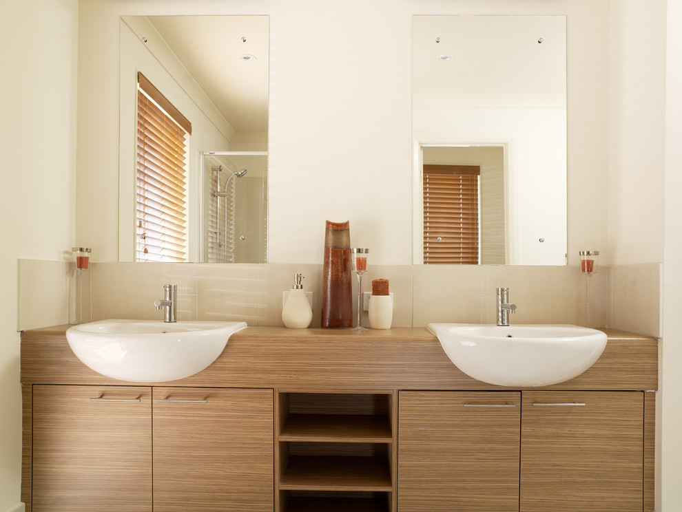 This is an example of a medium sized traditional ensuite bathroom in Perth with a submerged sink, flat-panel cabinets, medium wood cabinets, laminate worktops, beige tiles and beige walls.