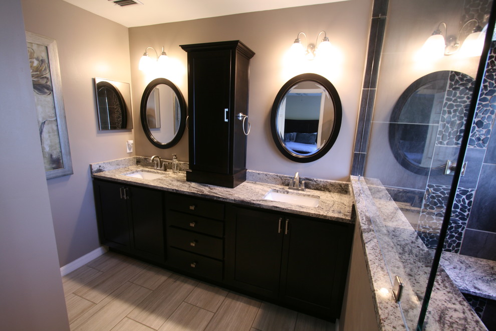 Exemple d'une salle de bain principale tendance en bois foncé avec un placard à porte shaker, une douche ouverte, une plaque de galets, un mur beige, un sol en carrelage de céramique, un lavabo encastré et un plan de toilette en stéatite.