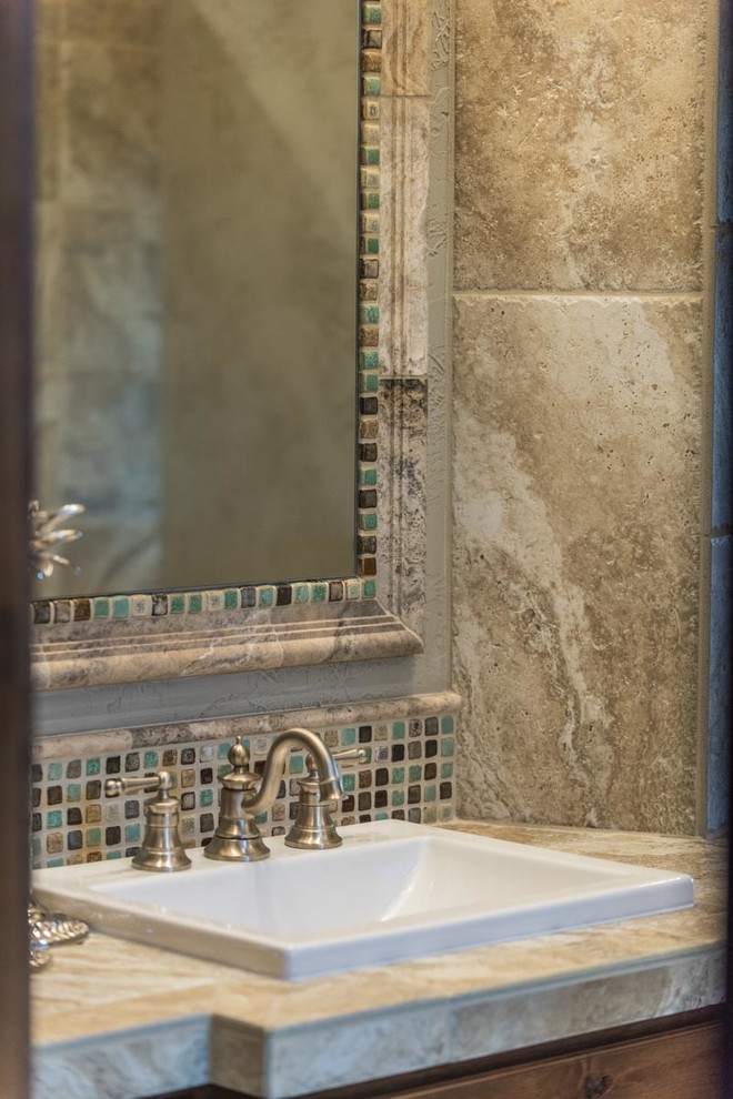 Modelo de cuarto de baño de estilo americano extra grande con puertas de armario de madera oscura, baldosas y/o azulejos beige, paredes grises, suelo de madera en tonos medios, aseo y ducha, lavabo encastrado y encimera de azulejos