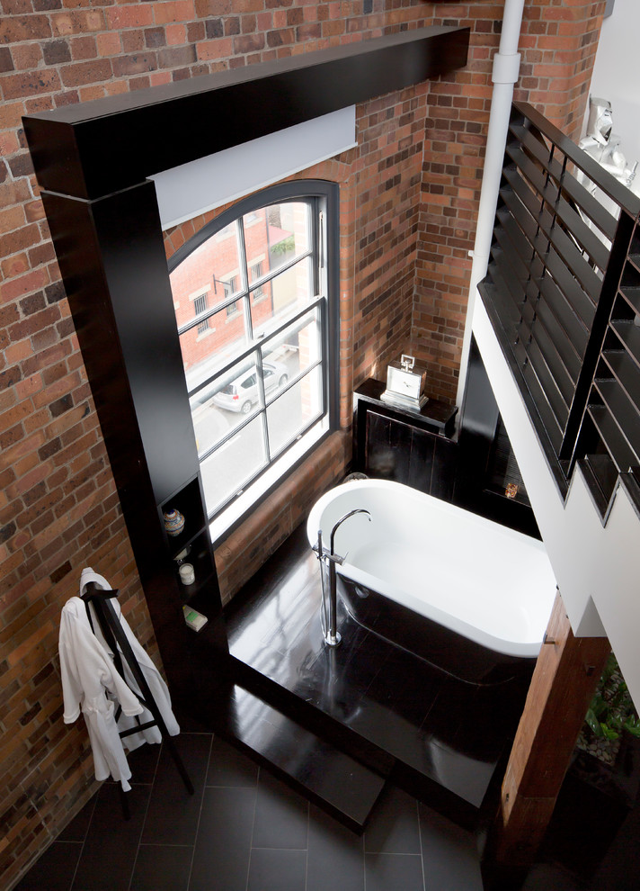 Idee per un'ampia stanza da bagno padronale industriale con vasca freestanding, piastrelle nere e pistrelle in bianco e nero