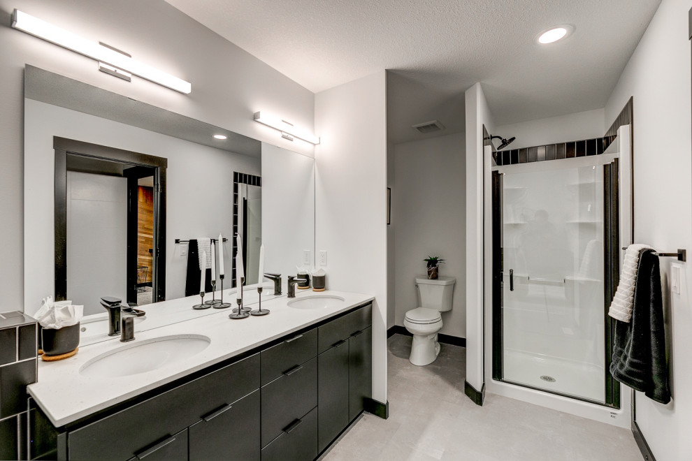 Inspiration for a mid-sized transitional master black tile and ceramic tile vinyl floor, gray floor and double-sink bathroom remodel in Edmonton with flat-panel cabinets, black cabinets, a one-piece toilet, white walls, an undermount sink, quartzite countertops, a hinged shower door, multicolored countertops and a built-in vanity