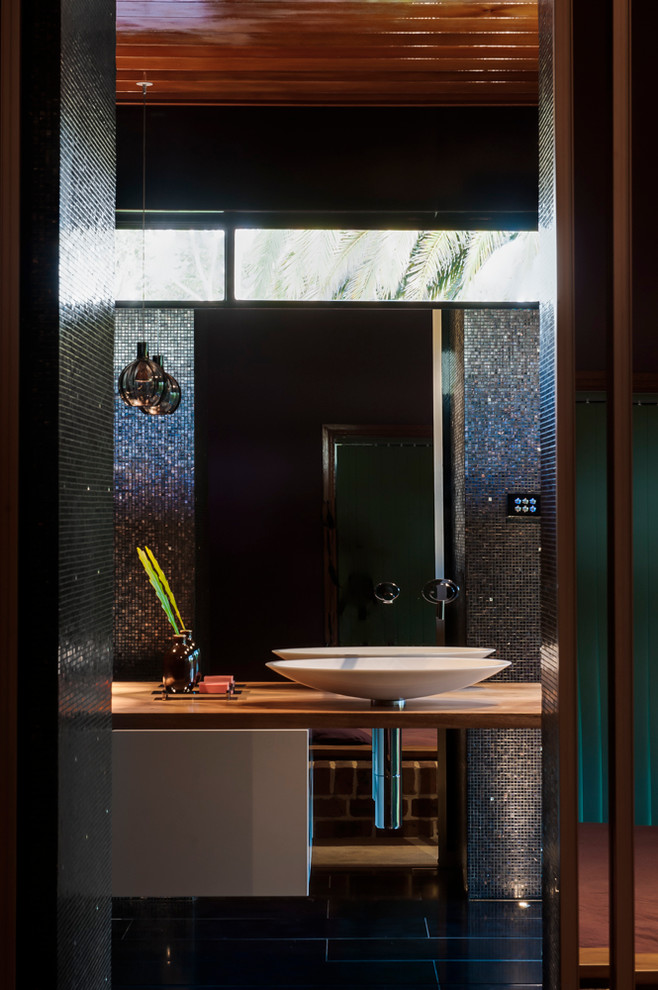 Esempio di una stanza da bagno con doccia contemporanea di medie dimensioni con ante bianche, top in legno, doccia aperta, WC sospeso, piastrelle nere, piastrelle a mosaico, pareti nere e pavimento con piastrelle in ceramica