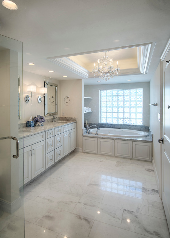 Large classic ensuite bathroom in Miami with recessed-panel cabinets, white cabinets, a double shower, a two-piece toilet, white walls, marble flooring, a submerged sink, grey floors, a hinged door, a built-in bath, grey tiles, white tiles, marble tiles and granite worktops.