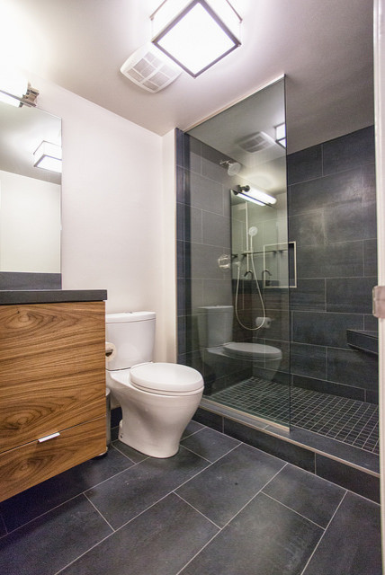 This is an example of a medium sized modern ensuite bathroom in DC Metro with an integrated sink, concrete worktops, grey tiles, ceramic tiles, white walls, ceramic flooring, flat-panel cabinets, medium wood cabinets, an alcove shower and a two-piece toilet.