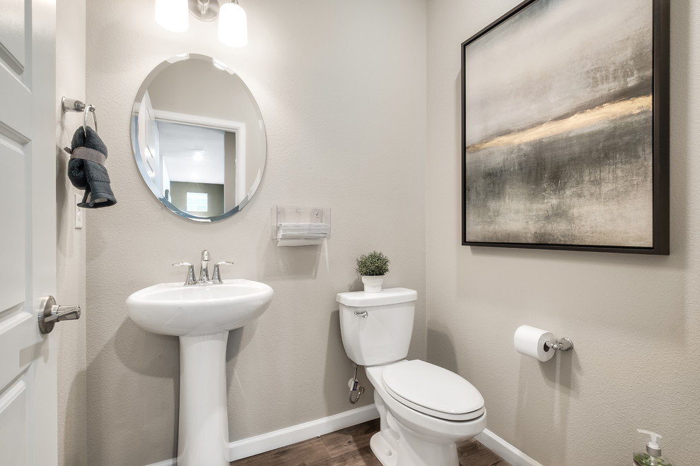 Exempel på ett litet klassiskt badrum, med en toalettstol med hel cisternkåpa, beige väggar, laminatgolv, ett piedestal handfat och grått golv