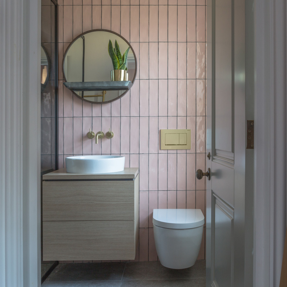 Foto di una stanza da bagno design con ante lisce, ante in legno chiaro, piastrelle rosa, lavabo a bacinella, top in legno, pavimento grigio, top beige, un lavabo e mobile bagno sospeso