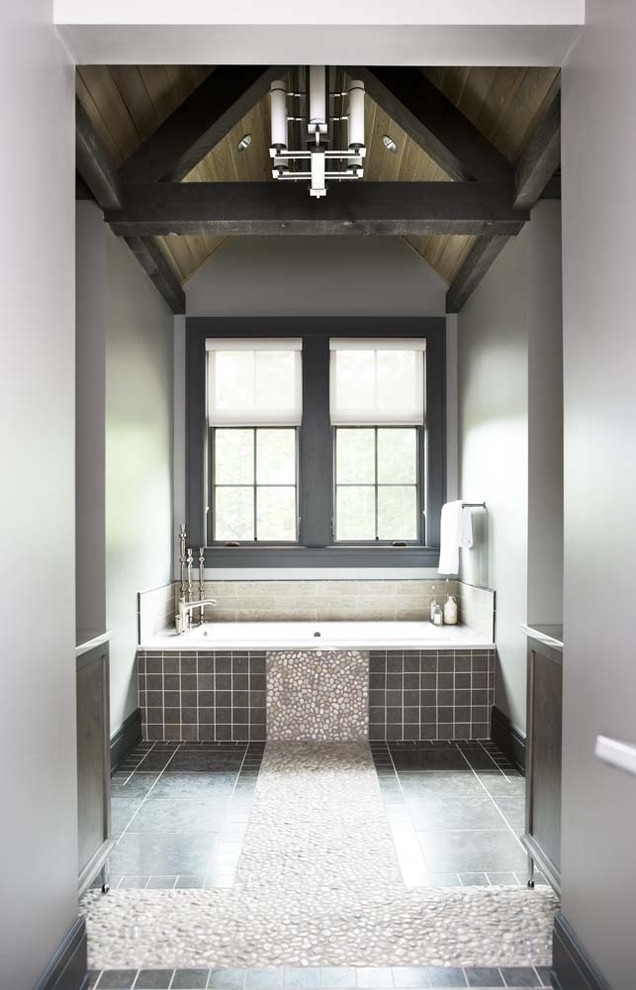 Esempio di una grande stanza da bagno padronale stile rurale con piastrelle grigie, piastrelle di ciottoli, pavimento con piastrelle di ciottoli, vasca ad alcova e pareti grigie