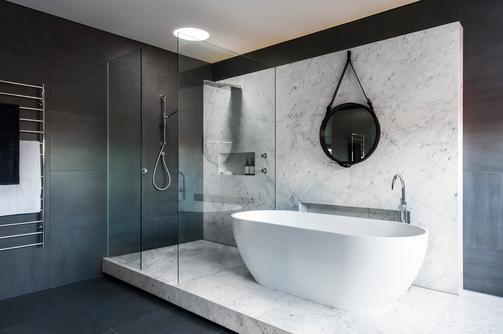 На фото: большая главная ванная комната в современном стиле с отдельно стоящей ванной, открытым душем, серой плиткой, плиткой из листового камня, серыми стенами и полом из керамической плитки с