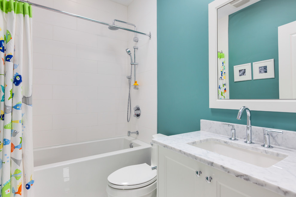 Idéer för mellanstora vintage badrum för barn, med ett undermonterad handfat, skåp i shakerstil, vita skåp, marmorbänkskiva, ett badkar i en alkov, en dusch/badkar-kombination, en toalettstol med separat cisternkåpa, vit kakel, porslinskakel, blå väggar och marmorgolv