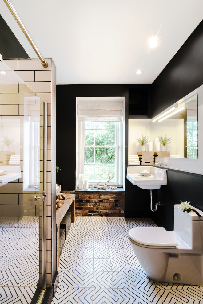 プロビデンスにある高級な中くらいなインダストリアルスタイルのおしゃれなマスターバスルーム (アルコーブ型シャワー、一体型トイレ	、黒い壁、セラミックタイルの床、壁付け型シンク、マルチカラーの床、開き戸のシャワー) の写真