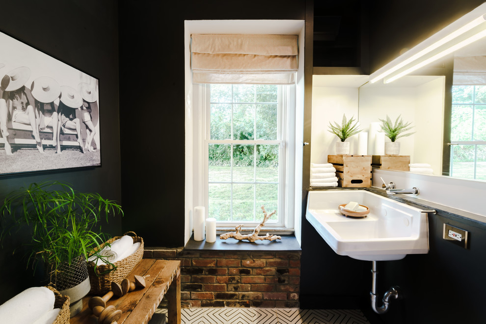 Inspiration for a mid-sized industrial master ceramic tile and multicolored floor alcove shower remodel in Providence with a one-piece toilet, black walls, a wall-mount sink and a hinged shower door