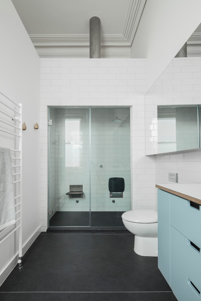 Ejemplo de cuarto de baño principal contemporáneo de tamaño medio con puertas de armario azules, baldosas y/o azulejos grises, baldosas y/o azulejos de cerámica, paredes blancas, suelo de baldosas de porcelana y encimera de laminado
