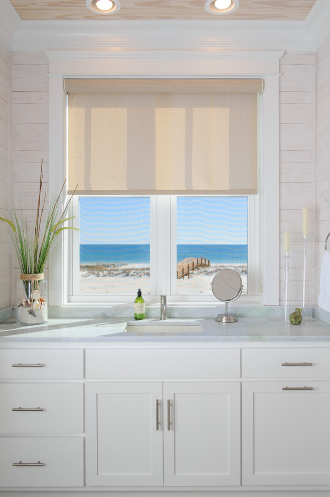 Réalisation d'une salle de bain marine avec des portes de placard blanches.