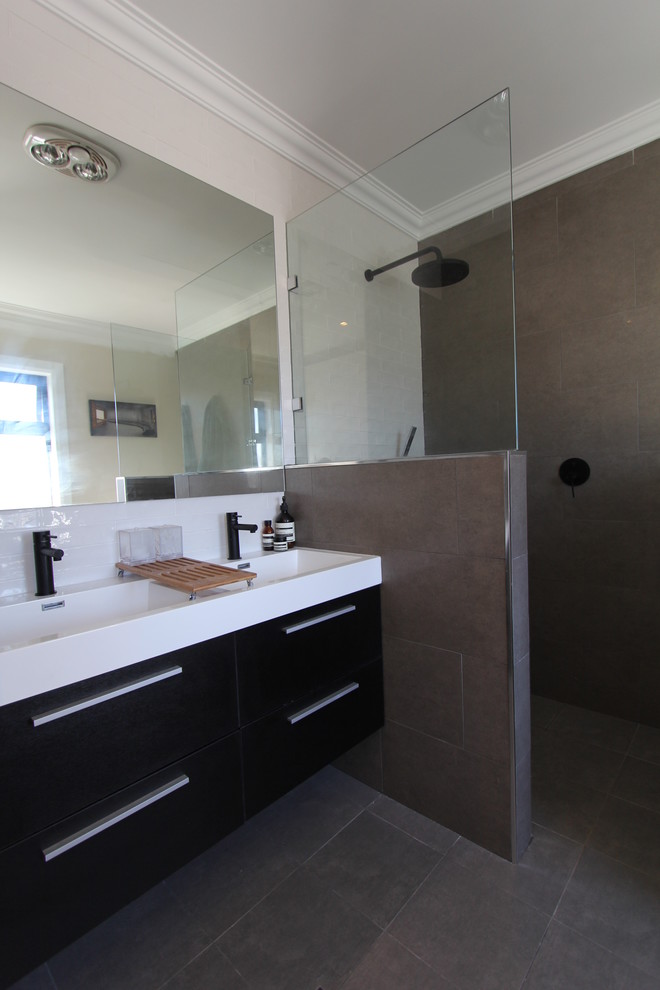 Идея дизайна: главная ванная комната среднего размера в современном стиле с монолитной раковиной, отдельно стоящей ванной, открытым душем, серой плиткой и каменной плиткой