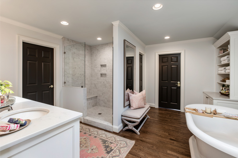 Idéer för ett mellanstort vit en-suite badrum, med luckor med infälld panel, vita skåp, ett fristående badkar, en dusch i en alkov, mörkt trägolv, ett undermonterad handfat, marmorbänkskiva, brunt golv och dusch med gångjärnsdörr