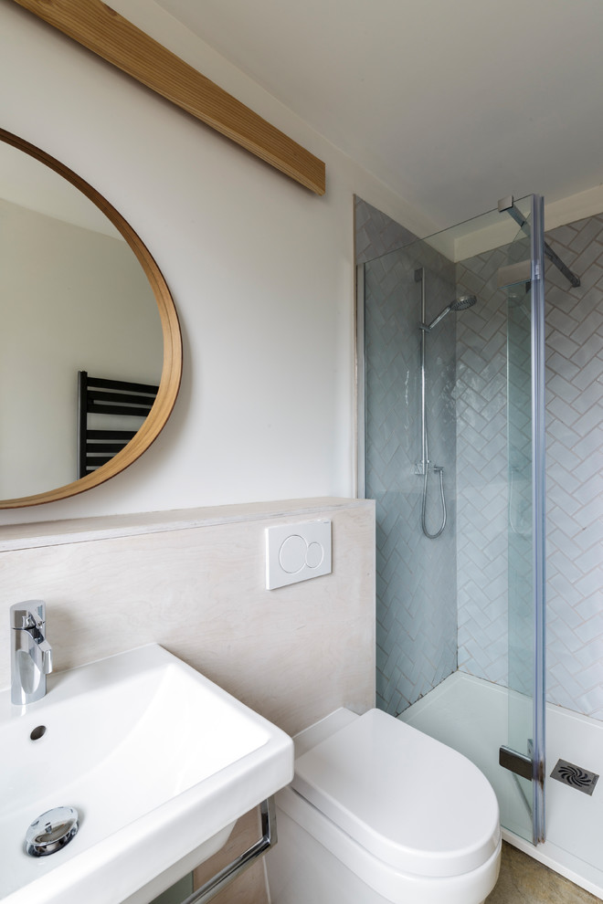 Small trendy master gray tile and ceramic tile concrete floor doorless shower photo in Gloucestershire with a wall-mount toilet, white walls and a wall-mount sink