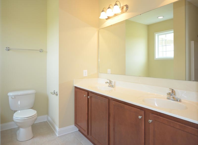 Photo of a contemporary bathroom in Raleigh with an integrated sink, medium wood cabinets, an alcove bath, a corner shower and a two-piece toilet.