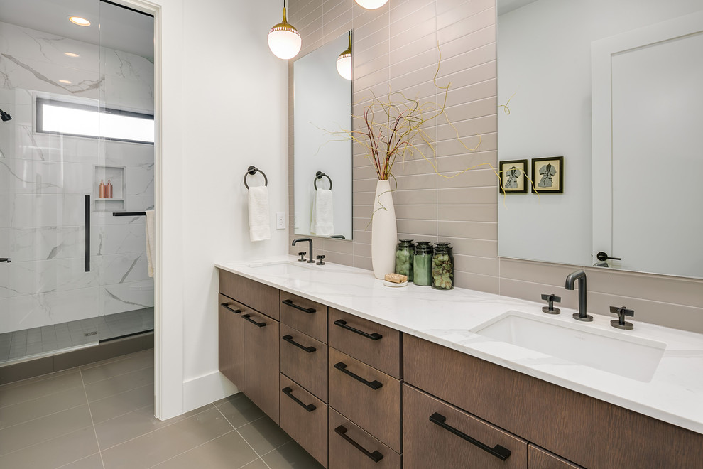 Cette photo montre une grande salle de bain tendance en bois brun avec un placard à porte plane, un carrelage gris, un mur blanc, un lavabo encastré, un plan de toilette en quartz modifié, un sol gris, une cabine de douche à porte battante et un plan de toilette blanc.
