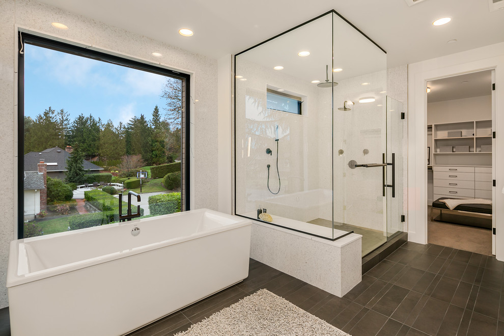 Exemple d'une grande salle de bain principale tendance avec un placard à porte plane, des portes de placard grises, une baignoire indépendante, un carrelage gris, un mur blanc, un lavabo encastré, un plan de toilette en quartz modifié, un sol gris et un plan de toilette blanc.