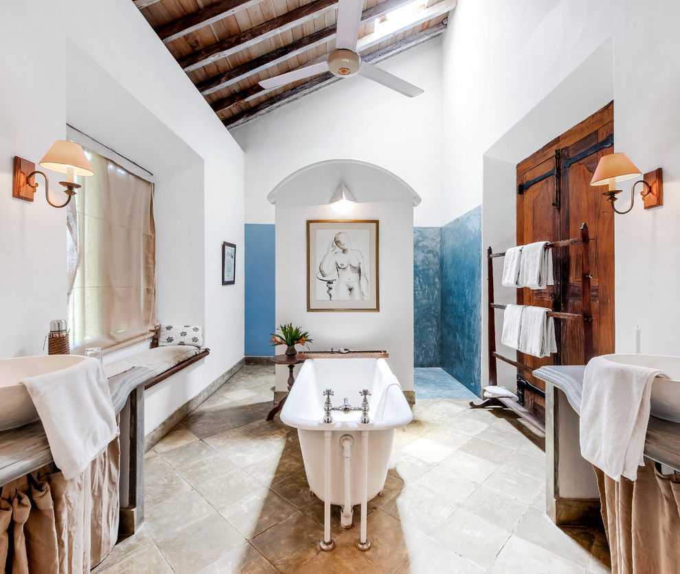 Exemple d'une grande salle de bain principale romantique avec une baignoire indépendante, une douche ouverte, du carrelage en pierre calcaire, un sol en carrelage de céramique, un plan de toilette en bois, un sol beige et aucune cabine.