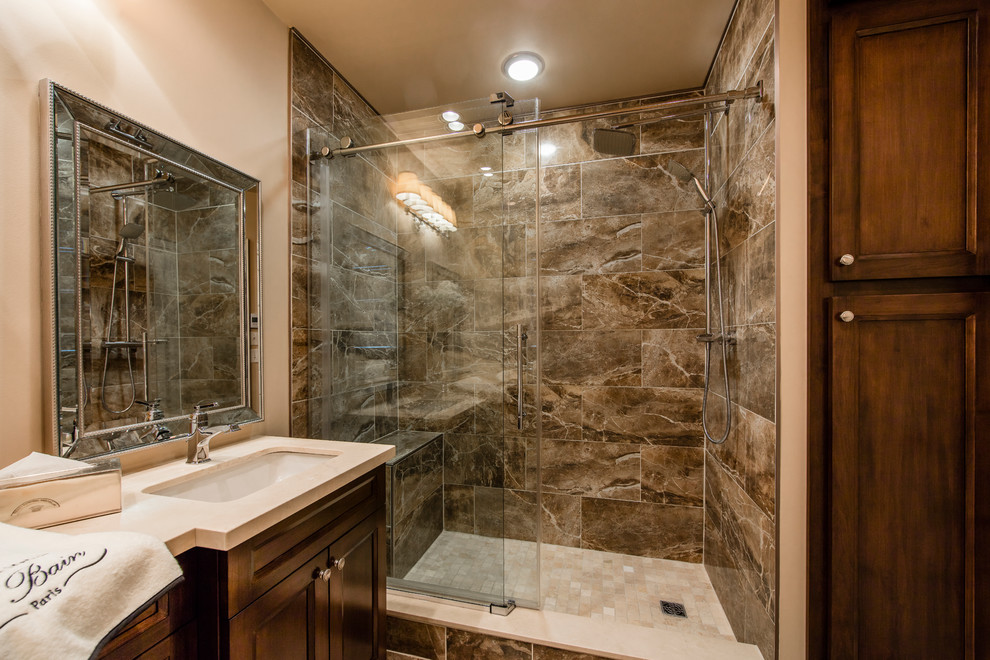 Medium sized traditional ensuite bathroom in Toronto with freestanding cabinets, medium wood cabinets, a double shower, a two-piece toilet, brown tiles, porcelain tiles, beige walls, porcelain flooring, a submerged sink and limestone worktops.
