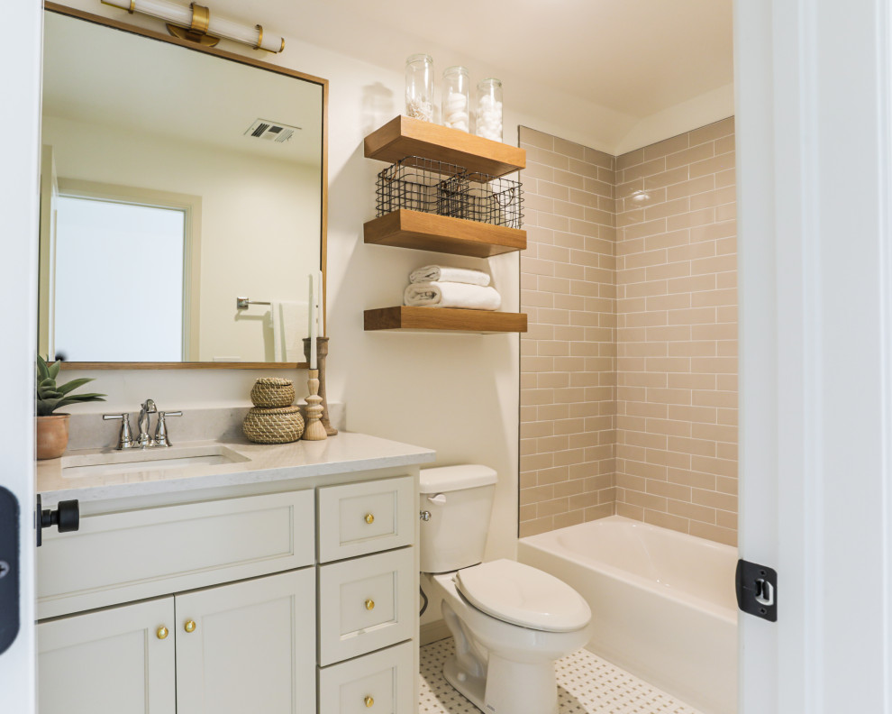 Идея дизайна: ванная комната среднего размера в классическом стиле с фасадами в стиле шейкер, бежевыми фасадами, ванной в нише, душем над ванной, унитазом-моноблоком, белой плиткой, керамогранитной плиткой, белыми стенами, полом из мозаичной плитки, душевой кабиной, врезной раковиной, столешницей из искусственного кварца, белым полом, шторкой для ванной, белой столешницей, тумбой под одну раковину и встроенной тумбой