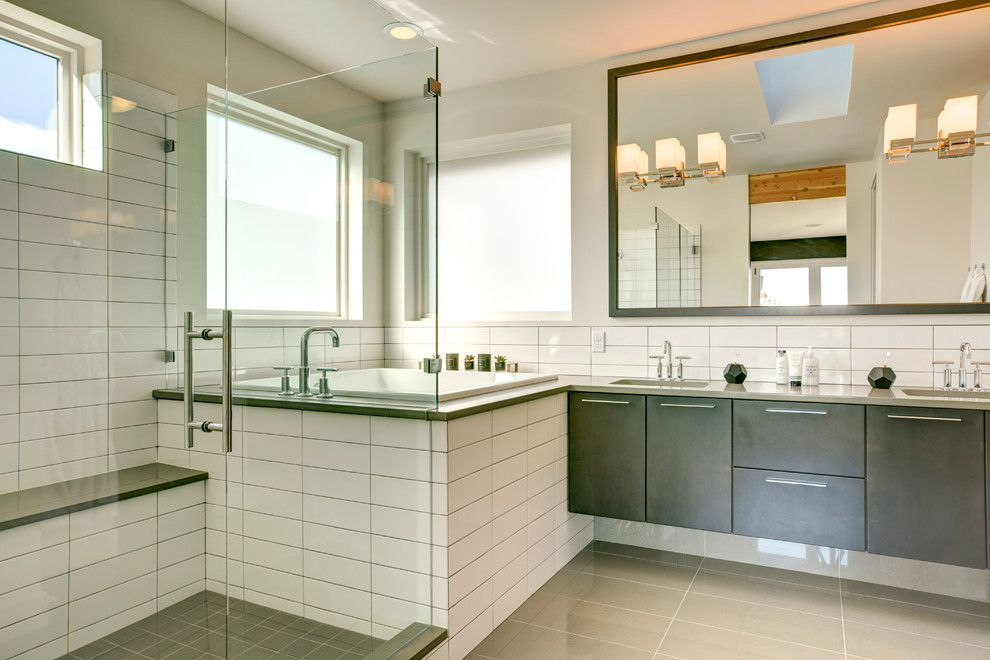 Cette photo montre une grande salle de bain principale chic en bois foncé avec un placard à porte plane, une baignoire posée, une douche d'angle, un carrelage blanc, des carreaux de céramique, un mur blanc, un lavabo encastré, un sol gris et une cabine de douche à porte battante.