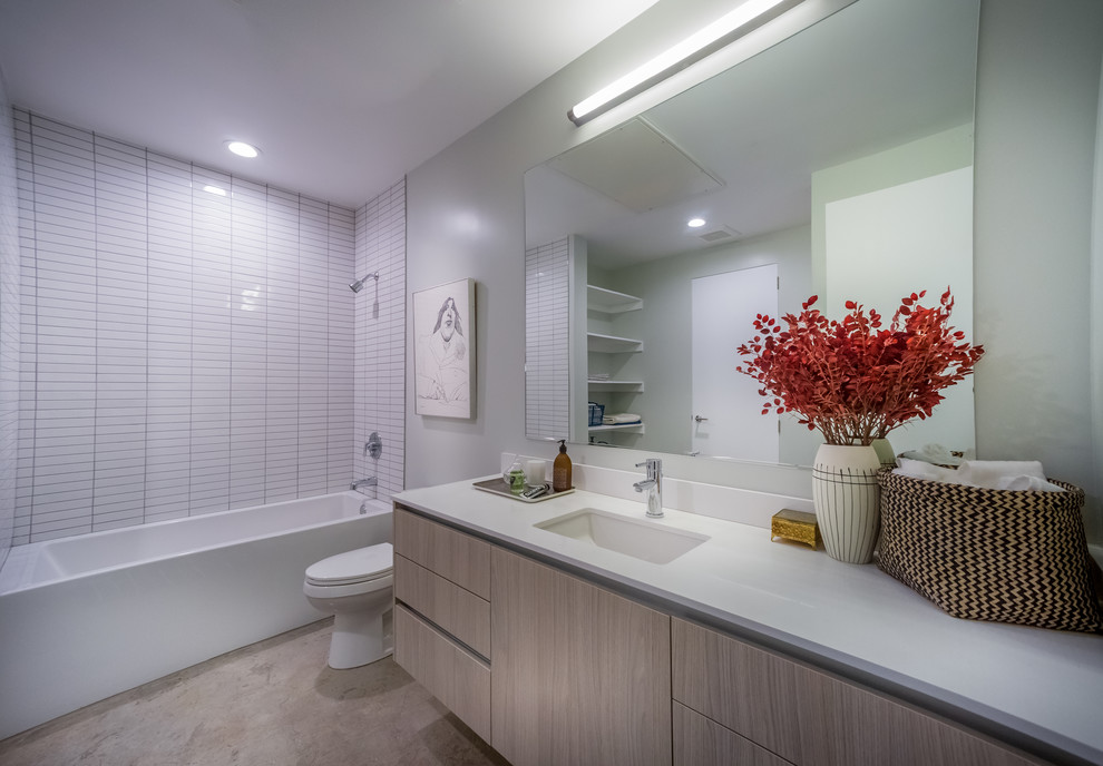 ロサンゼルスにあるモダンスタイルのおしゃれな浴室 (オーバーカウンターシンク、フラットパネル扉のキャビネット、茶色いキャビネット、珪岩の洗面台、大型浴槽、オープン型シャワー、一体型トイレ	、白いタイル、磁器タイル、白い壁、コンクリートの床) の写真