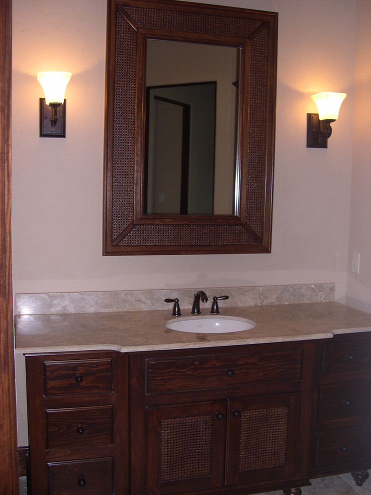 Idée de décoration pour une grande salle de bain tradition en bois brun avec un placard en trompe-l'oeil, un carrelage beige, un mur beige, un sol en travertin, un lavabo encastré et un plan de toilette en marbre.