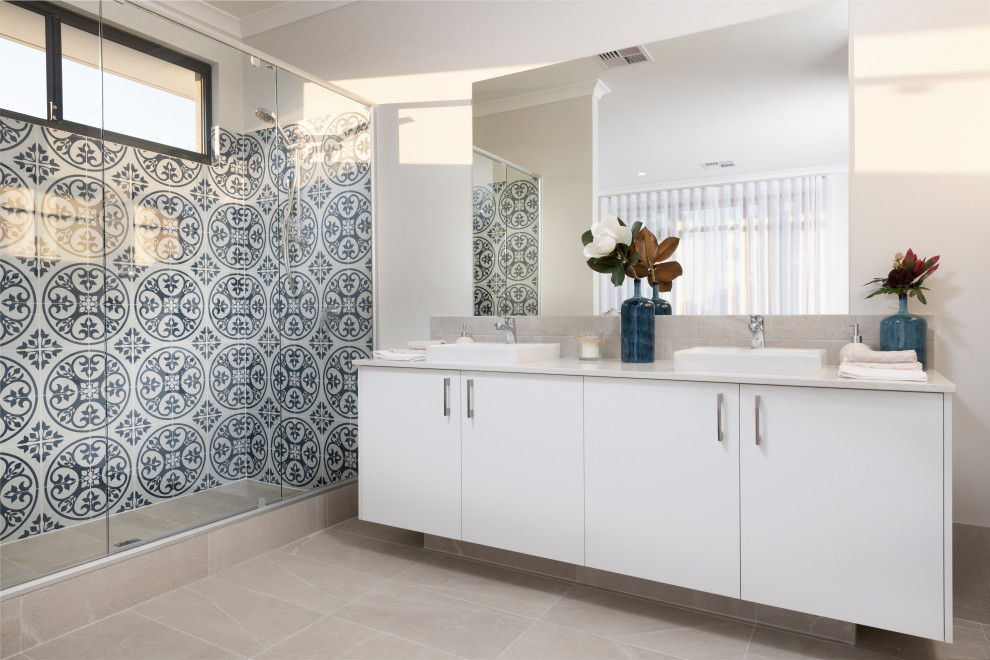 Идея дизайна: главная ванная комната в современном стиле с плоскими фасадами, белыми фасадами, душем в нише, синей плиткой, белой плиткой, бежевыми стенами, настольной раковиной, бежевым полом и душем с раздвижными дверями
