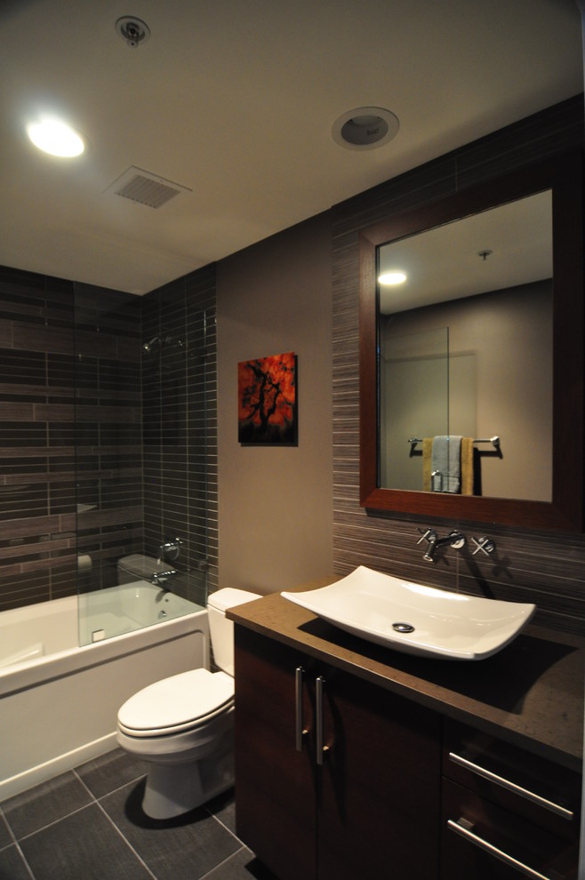 Design ideas for a large contemporary ensuite bathroom in Chicago with a vessel sink, flat-panel cabinets, dark wood cabinets, engineered stone worktops, an alcove shower, a two-piece toilet, grey tiles, mosaic tiles, grey walls and porcelain flooring.