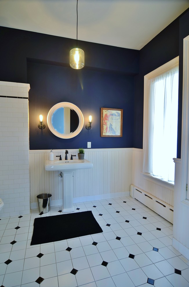 This is an example of a medium sized vintage ensuite bathroom in New York with a corner bath, a shower/bath combination, a one-piece toilet, grey walls, ceramic flooring and a pedestal sink.