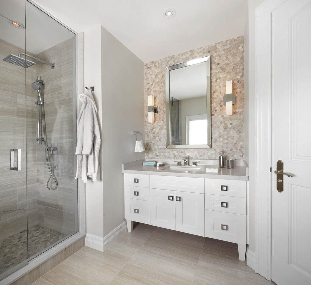 На фото: ванная комната в стиле неоклассика (современная классика) с врезной раковиной, фасадами в стиле шейкер, белыми фасадами, серой плиткой, серыми стенами, полом из керамической плитки и серой столешницей с