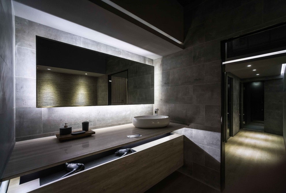 Medium sized contemporary bathroom in Hong Kong with grey cabinets, a shower/bath combination, grey tiles, cement tiles, grey walls, light hardwood flooring and concrete worktops.