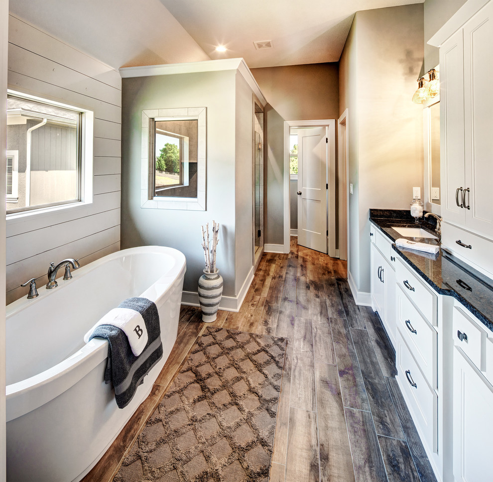 This is an example of a medium sized traditional ensuite bathroom in Kansas City with flat-panel cabinets, white cabinets, an alcove shower, a two-piece toilet, white walls, ceramic flooring, a submerged sink, granite worktops, multi-coloured floors and a hinged door.