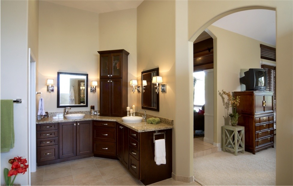 Klassisk inredning av ett stort en-suite badrum, med ett fristående handfat, luckor med infälld panel, skåp i mörkt trä, granitbänkskiva, ett fristående badkar, en öppen dusch, flerfärgad kakel, stenkakel, beige väggar och travertin golv