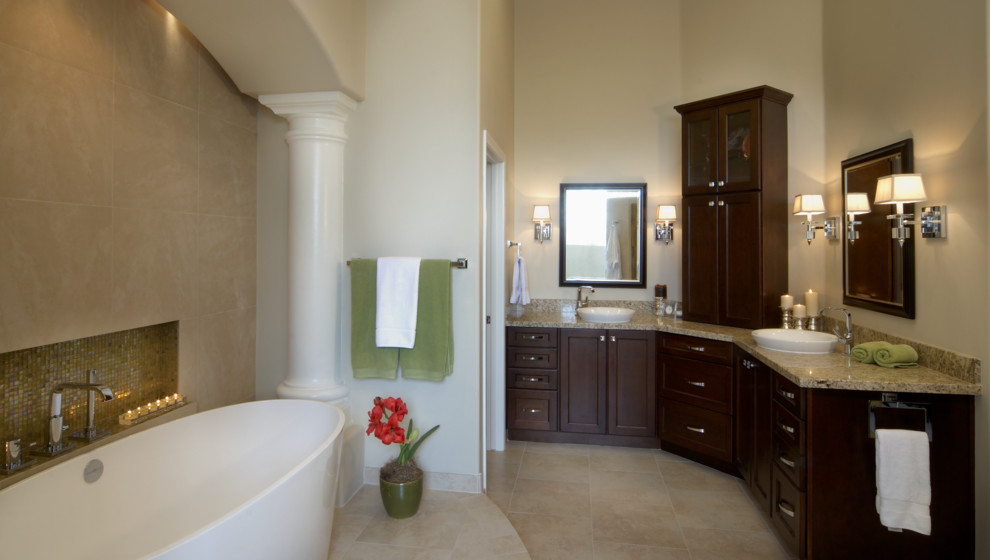 Large elegant master multicolored tile and stone tile travertine floor bathroom photo in Phoenix with a vessel sink, recessed-panel cabinets, dark wood cabinets, granite countertops and beige walls