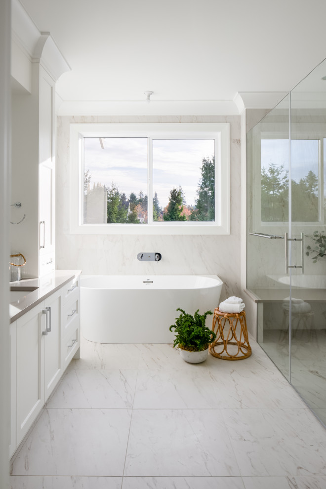 Example of a large transitional master white tile and porcelain tile porcelain tile, white floor and single-sink bathroom design in Vancouver with shaker cabinets, white cabinets, white walls, an undermount sink, quartz countertops, a hinged shower door, beige countertops and a built-in vanity