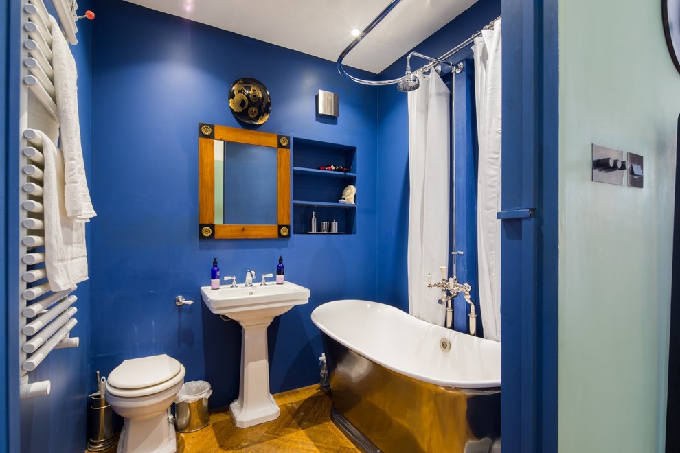 Источник вдохновения для домашнего уюта: детская ванная комната среднего размера в стиле модернизм с отдельно стоящей ванной, душем над ванной, синими стенами, шторкой для ванной, открытыми фасадами, синими фасадами, унитазом-моноблоком, темным паркетным полом, раковиной с пьедесталом и коричневым полом