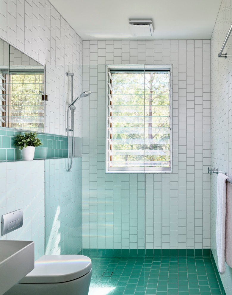 Foto di una stanza da bagno minimal con piastrelle bianche, lavabo sospeso, pavimento turchese e un lavabo