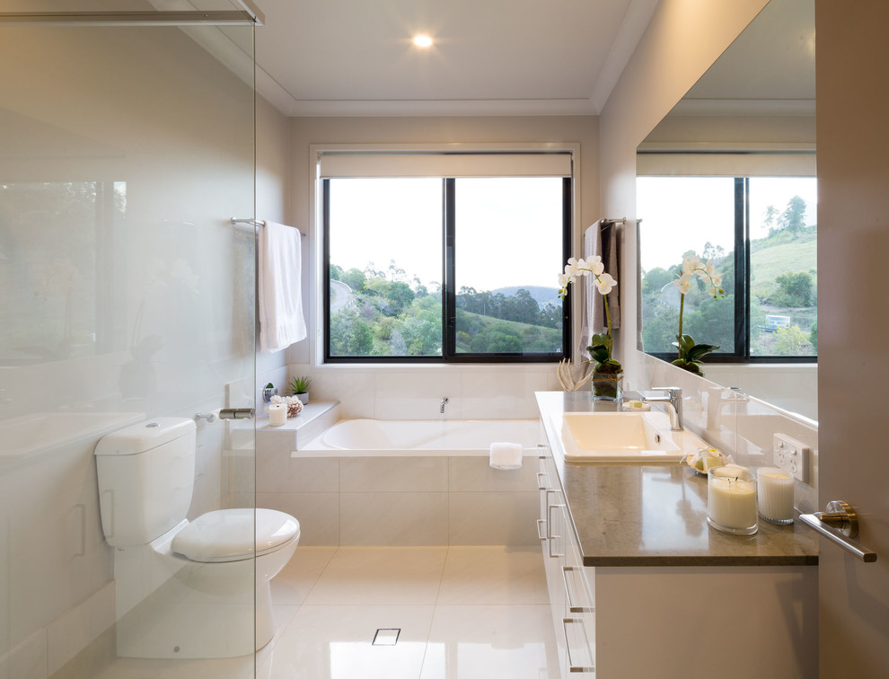 Пример оригинального дизайна: главная ванная комната в современном стиле с плоскими фасадами, белыми фасадами, ванной в нише, угловым душем, унитазом-моноблоком, бежевой плиткой, бежевыми стенами, накладной раковиной, бежевым полом, открытым душем и коричневой столешницей