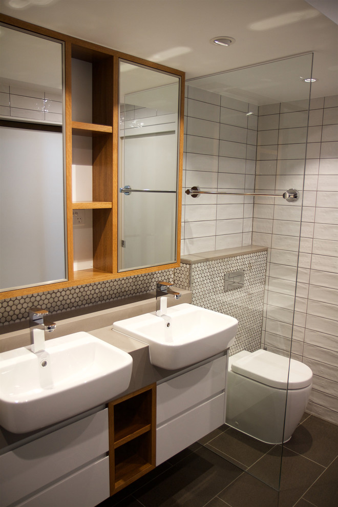 Idéer för att renovera ett mellanstort funkis badrum, med vita skåp, en hörndusch, vit kakel, keramikplattor, vita väggar, grått golv och dusch med gångjärnsdörr