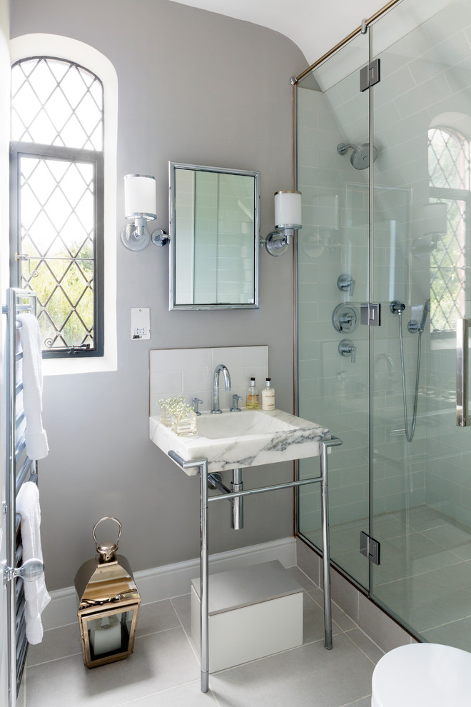 Foto de cuarto de baño clásico con lavabo tipo consola, encimera de mármol, ducha esquinera, paredes grises y aseo y ducha