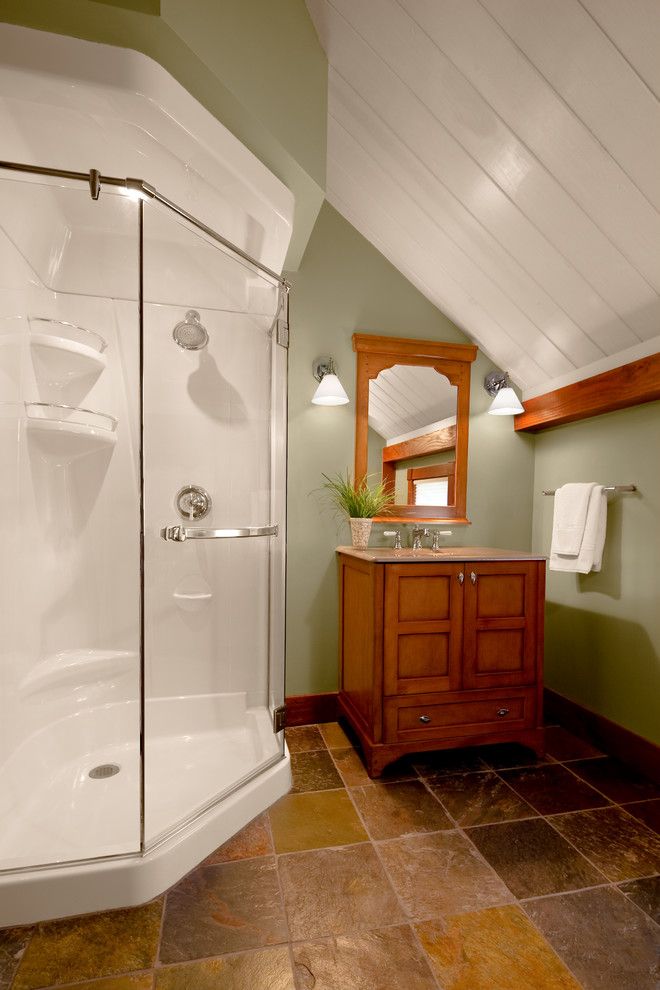 Esempio di una stanza da bagno con doccia tradizionale di medie dimensioni con ante in stile shaker, ante in legno scuro, doccia ad angolo, piastrelle grigie, piastrelle in pietra, pareti verdi e pavimento in travertino