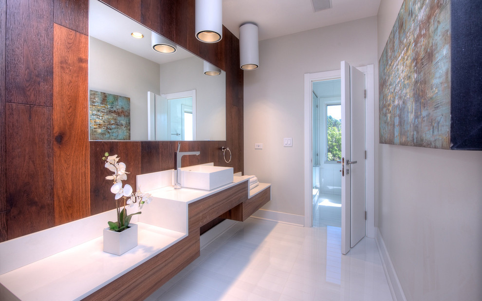 Réalisation d'une salle de bain principale design en bois foncé avec une vasque, un placard à porte plane et un mur gris.